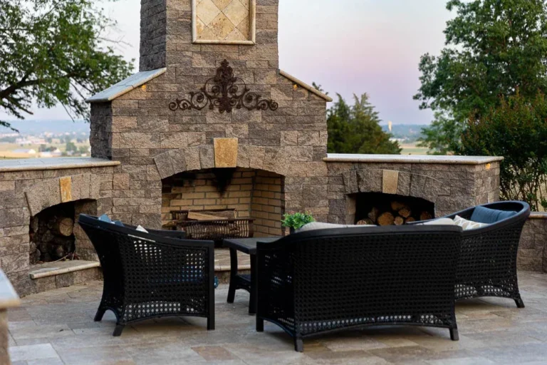 Elegant home exterior at night featuring well-lit entryway, landscaped gardens, and inviting pathway, showcasing outdoor lighting and hardscape design by Authentic Homescapes.