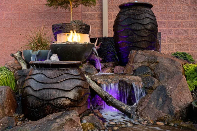 Patio area featuring a comfortable seating arrangement, stone steps, and lush greenery, illustrating an inviting outdoor living space designed for relaxation and hosting gatherings.