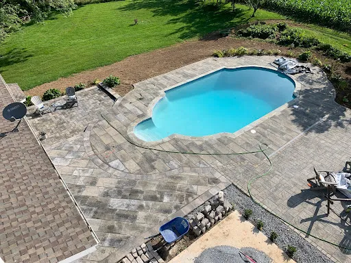 Outdoor kitchen with stainless steel grill, stone countertops, and ambient lighting, overlooking a scenic view, enhancing outdoor living and hosting experiences.