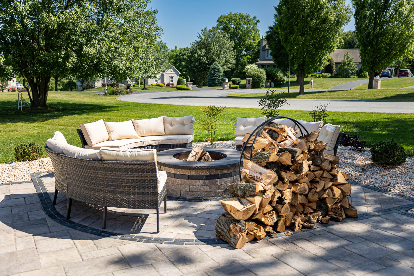 Fire place surrounded with outdoor sofas and a stack of firewood