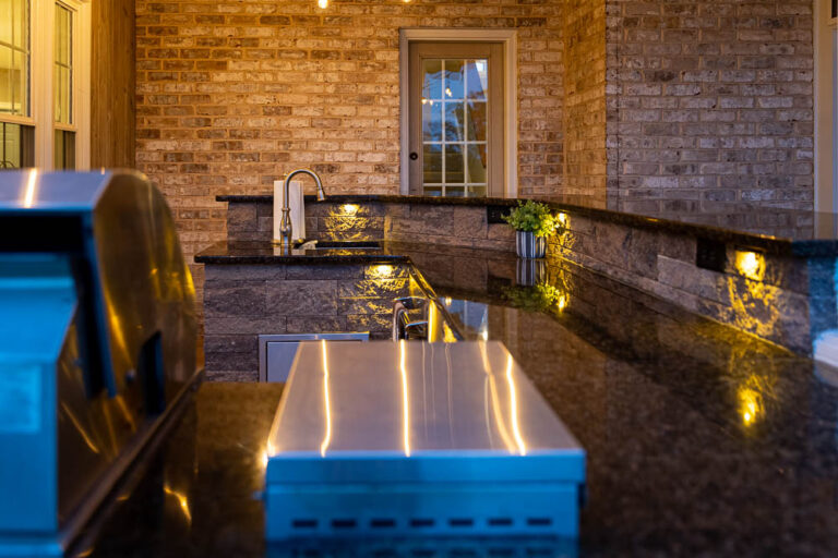 Beautiful landscaped outdoor space by Authentic Homescapes featuring artistic hardscape design and a tranquil water feature.