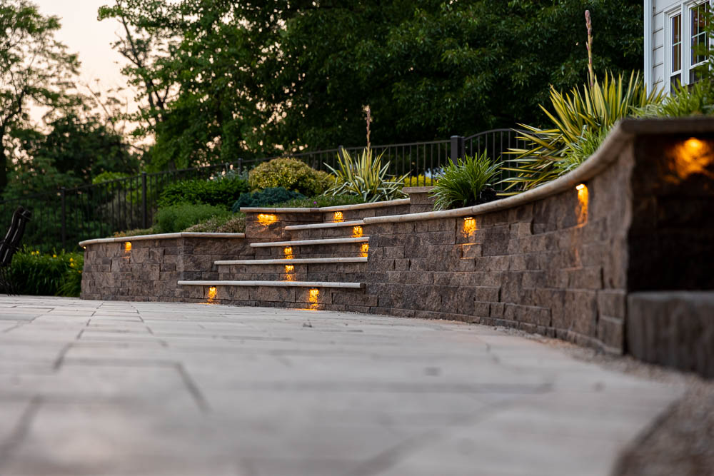 lights in a retaining wall beside a paver patio