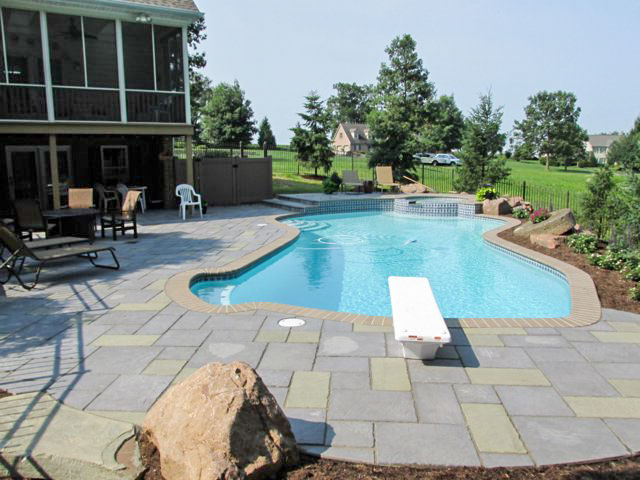 Paver pool deck surrounding an in-ground pool