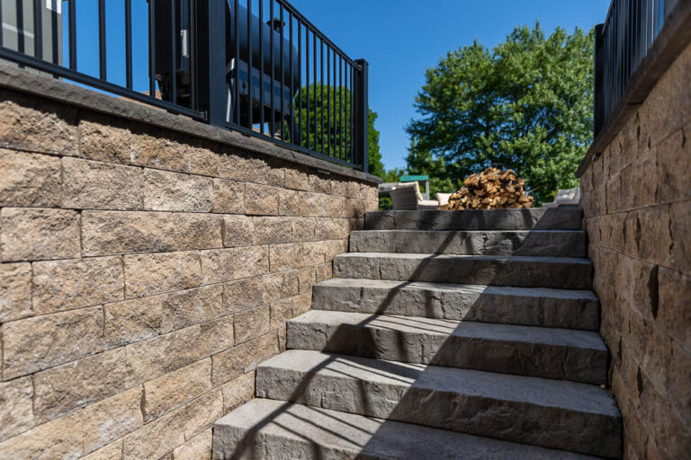 Stone retaining wall beside a paver patio