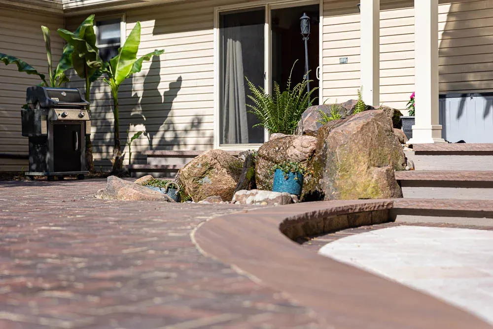 Patterned patio surface beside planted beds